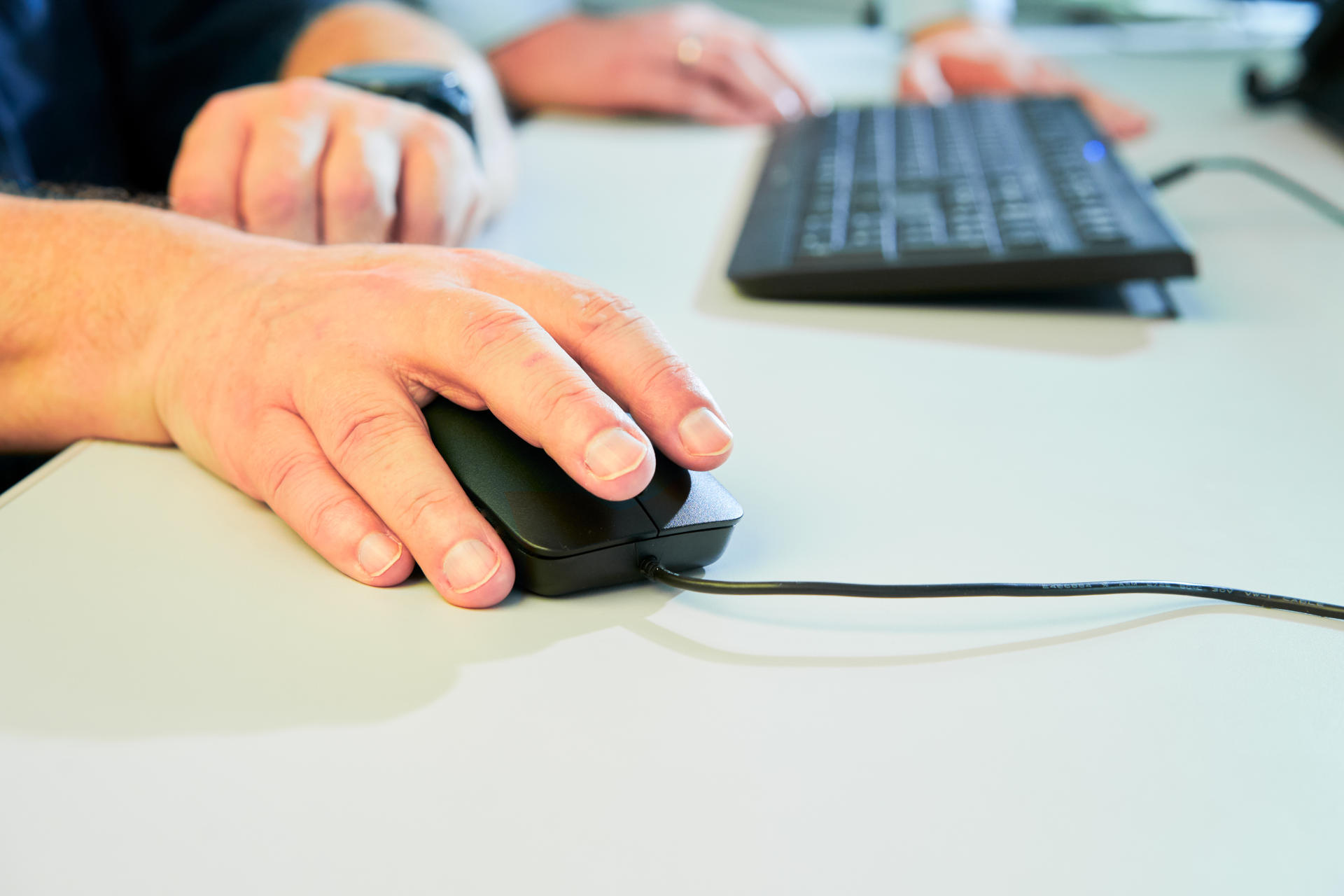 Employee with hand on computer mouse